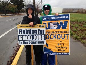 SEIU 503 retirees Nancy Greeman (left) and Catherine Stearns (right) stay active for economic justice on a windy and damp picket line standing up for Steelworkers locked out of their factory.