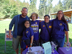 Lane Co. Labor Day: UO Higher Ed members stand with supporters at the Lane County Labor Day Picnic. From left-to-right, UO Graduate Teaching Fellows Federation member Joe Henry, UO Sublocal President Theodora Ko-Thompson, Eugene Labor Choir member Dorthy Attneave, SEIU 503 staff Marikio Yoshioka and SEIU 503 member Lauradel Collins.