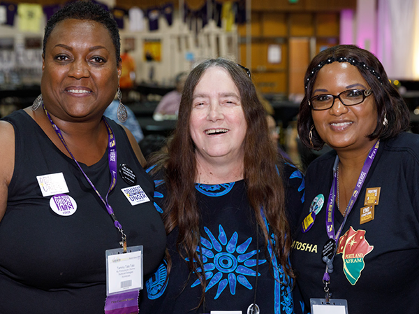 3 women smiling, wearing SEIU buttons and conference nametags