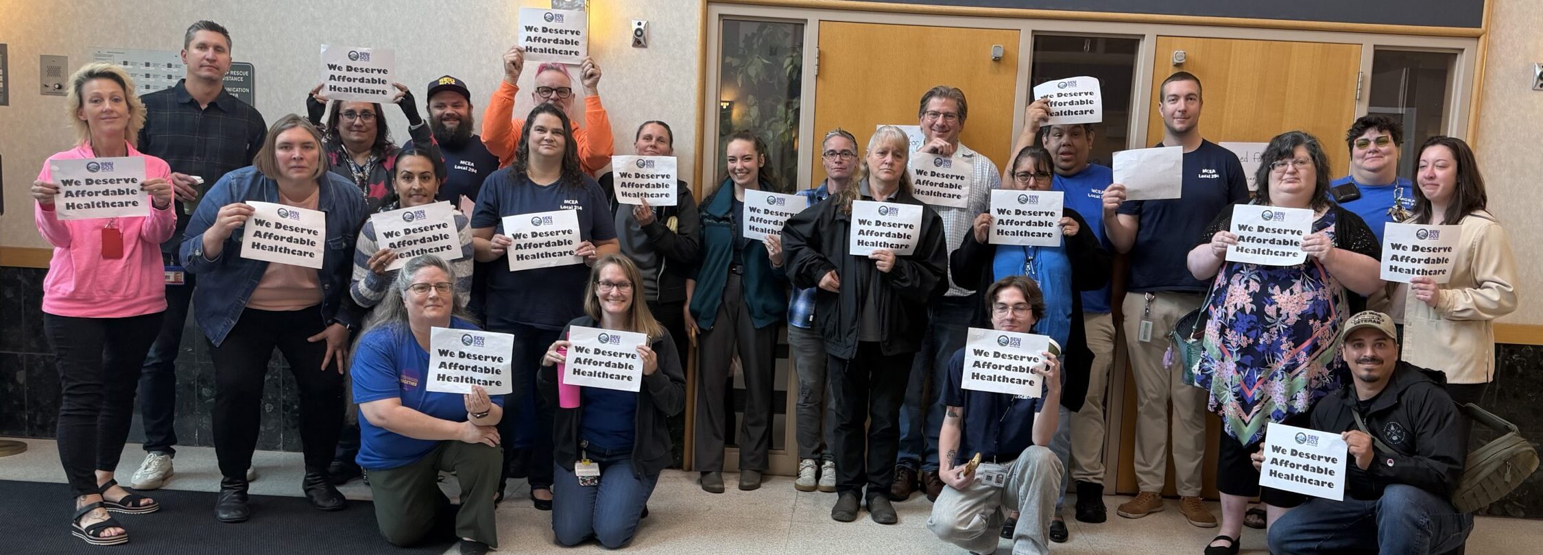A group of marion county workers holding signs that say 'We Deserve Affordable Healthcare"